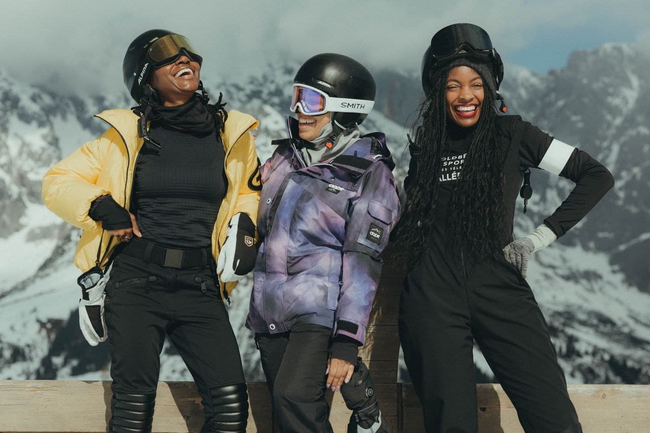 Three friends laughing in front of the Austrian Alps